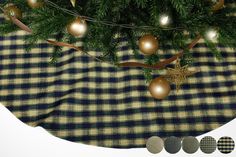 the christmas tree is decorated with gold ornaments and baubles on a checkered tablecloth