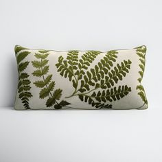 a green and white pillow with leaves on it