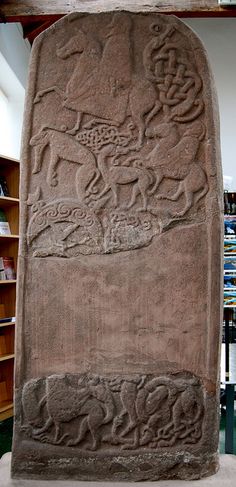 a large stone with carvings on it in a room filled with bookshelves and shelves