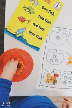 a young boy is playing with his blue fish book and its matching parts to read