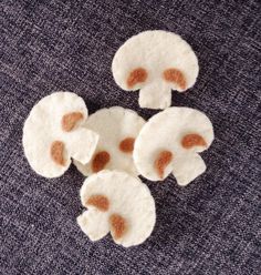 four pieces of felt with brown dots on them sitting on a blue cloth covered surface