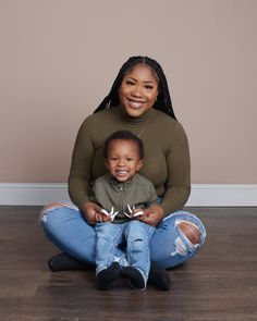 a woman sitting on the floor with her child