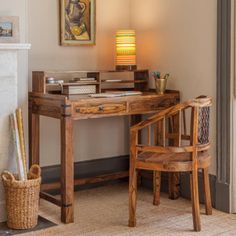 a wooden desk sitting next to a chair in a room with a painting on the wall