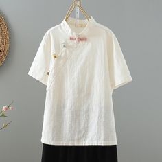 a white shirt hanging on a clothes rack next to a basket with flowers in it