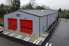 a truck parked in front of a building with two red garage doors on the side