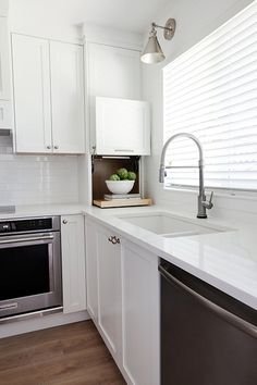 a kitchen with white cabinets and stainless steel appliances