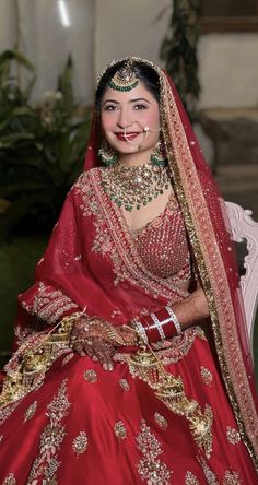 a woman in a red and gold bridal gown