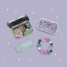 two tins filled with different items on top of a purple surface and white stars