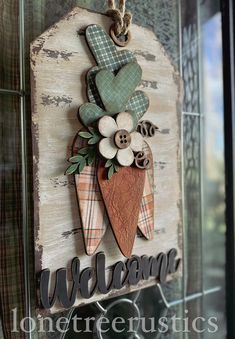 a wooden sign hanging on the side of a building with buttons and flowers in it