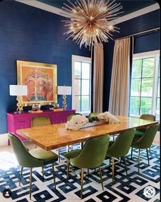 a dining room with blue walls and colorful furniture in the center, along with a chandelier that hangs from the ceiling