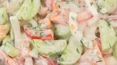 a salad with cucumbers, tomatoes and dill on it is shown close up