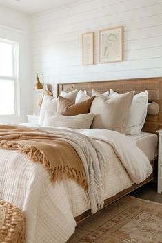 a bedroom with white walls and wooden headboard, beige bedding, and tan throw pillows