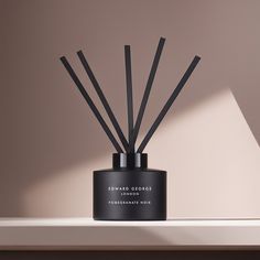 an image of a candle that is on the shelf with some sticks in front of it