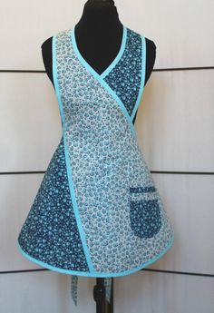 a dress on a mannequin with a blue and white flowered apron over it