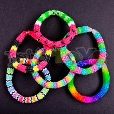 four bracelets with different colors and designs on black background, close up view photo