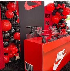 the nike store is decorated with red and black balls, balloons, and other items