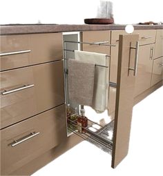 an open cabinet door in a kitchen with towels hanging on the bottom and side shelves