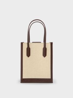 Cool and utterly chic, this geometric canvas tote bag is the perfect piece to complete any casual ensemble. Featuring a classic rectangular silhouette, a versatile cream-and-brown colourway, and lightweight canvas construction, this bag will slot seamlessly into your wardrobe rotation. Carry yours by the elongated double handles, or simply clip on the detachable strap and turn it into a crossbody bag for hands-free convenience. Rectangular Brown Box Bag In Coated Canvas, Beige Double Handle Box Bag With Dust Bag, Chic Coated Canvas Box Bag With Dust Bag, Square Brown Coated Canvas Bag, Brown Square Coated Canvas Bag, Beige Top Handle Box Bag For On-the-go, Rectangular Coated Canvas Box Bag, Rectangular Box Bag With Leather Handles For Shopping, Beige Satchel For Shopping With Dust Bag