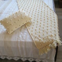 a white bed topped with pillows on top of a wooden floor