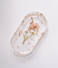 a plastic tray with flowers in it on a white tableclothed surface that is partially covered by dirt and flakes