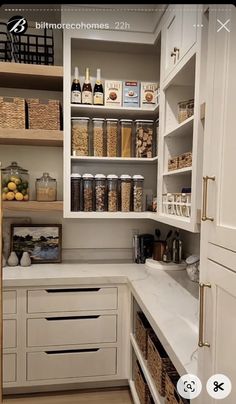 a kitchen with white cabinets and lots of food in the cupboards next to each other