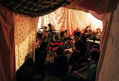 a group of people are sitting in a tent