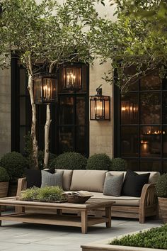 a couch and coffee table in front of a building with lights hanging from the windows