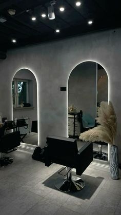 a hair salon with chairs, mirrors and lights