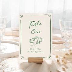 a place card sitting on top of a table next to wine glasses and silverware