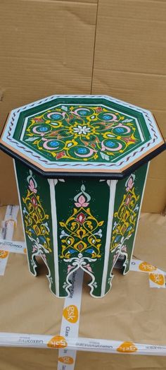 an elaborately painted wooden box sitting on top of cardboard