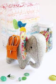 an elephant made out of felt sitting next to some buttons