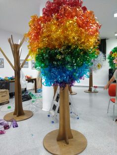 there is a colorful tree made out of plastic bottles in the middle of a room