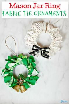 two christmas wreaths hanging from the side of a marble counter top with text overlay that says mason jar ring fabric tie ornaments