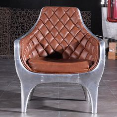 a brown leather chair sitting on top of a tiled floor