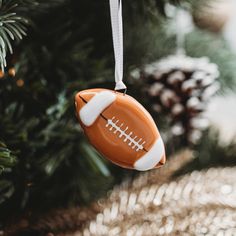 a football ornament hanging from a christmas tree