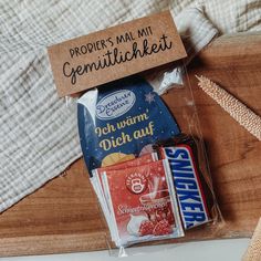 some kind of food wrapped in plastic on top of a wooden table next to other items