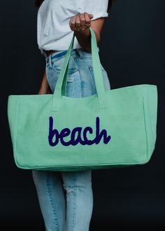 You'll be ready for the beach with this new bag! Our new colorful tote collection will have you vacation ready!  Mint green tote bag Navy "beach" textured text on the front Measures 11" x 20" x 6" Designed in the U.S.A. Produced in India.  100% Cotton Lining: 100% Polyester Trendy Green Travel Bag With Large Capacity, Green Large Capacity Trendy Travel Bag, Trendy Large Capacity Green Travel Bag, Green Large Capacity Canvas Bag For Travel, Large Capacity Green Canvas Travel Bag, Casual Green Travel Bag For Daily Use, Green Weekend Canvas Bag, Green Canvas Weekend Bag, Green Canvas Tote Bag For Travel