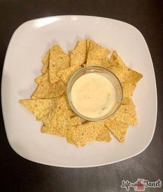 a white plate topped with tortilla chips and dip