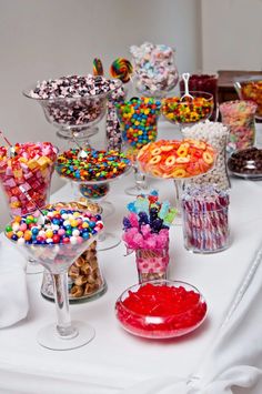 a table topped with lots of candy and candies on top of glass vases