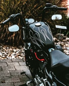 a black motorcycle parked on top of a brick road