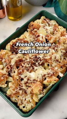 a green casserole dish filled with cauliflower and cheese