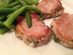 some meat and green beans on a white plate