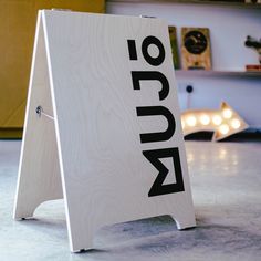 a wooden sign with the word run written on it in black and white letters sitting on top of a gray floor