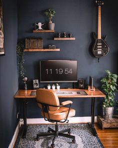 a home office with a guitar on the wall and a desk in front of it