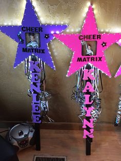 three purple and pink star decorations in front of a metallic wall with the words cheer matrix on them