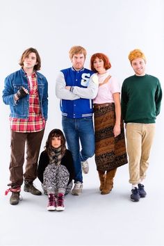 four people standing in front of a white background