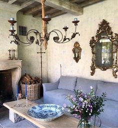 a living room filled with furniture and a fire place under a chandelier next to a fireplace