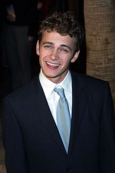 a smiling young man in a suit and tie