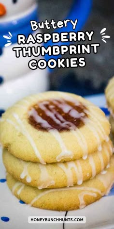 buttery raspberry thumbprint cookies on a blue and white plate