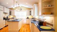 a large kitchen with white cabinets and blue counter tops is pictured in this image from the inside